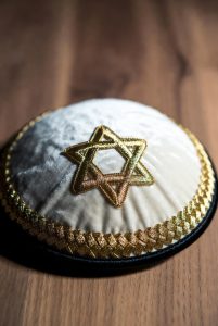 White velvet Kippah with gold rim and raised gold Star of David embroidery.