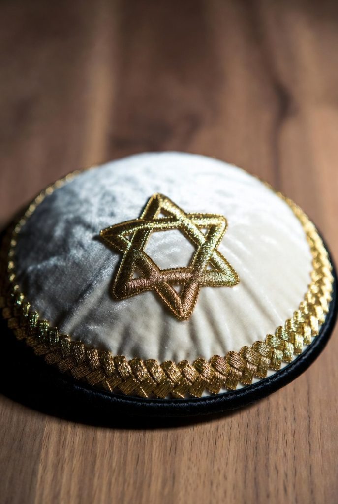 White velvet Kippah with gold rim and raised gold Star of David embroidery.